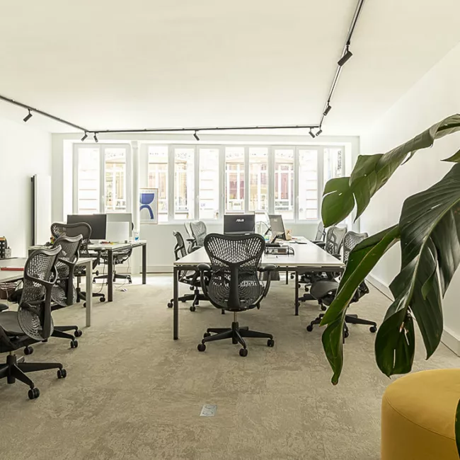 Espace de travail, quartier Sentier, flexible avec des bureaux modulables, des chaises ergonomiques, et des séparateurs amovibles, permettant différentes configurations pour le travail collaboratif ou individuel.