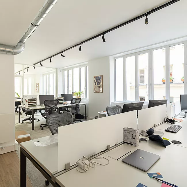 Espace de travail, quartier Sentier, flexible avec des bureaux modulables, des chaises ergonomiques, et des séparateurs amovibles, permettant différentes configurations pour le travail collaboratif ou individuel.