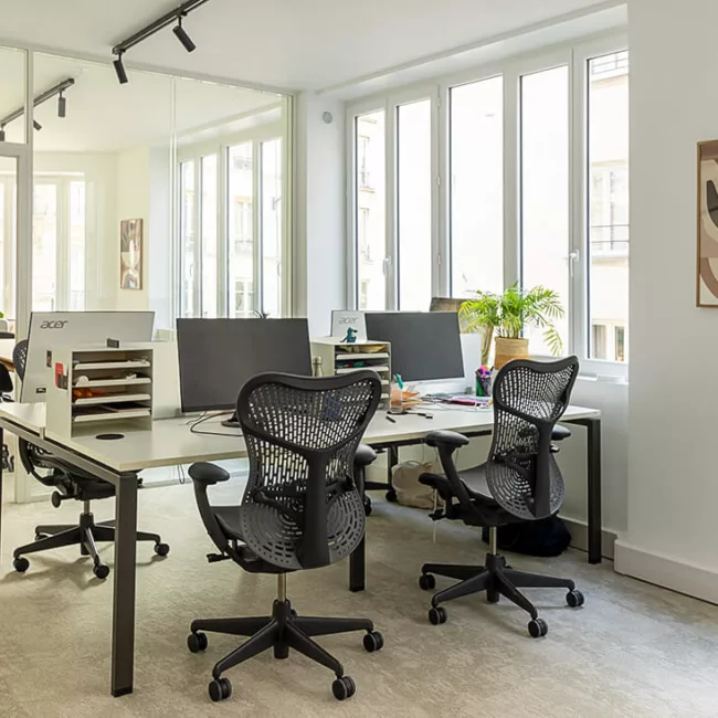 Espace de travail, quartier Sentier, flexible avec des bureaux modulables, des chaises ergonomiques, et des séparateurs amovibles, permettant différentes configurations pour le travail collaboratif ou individuel.