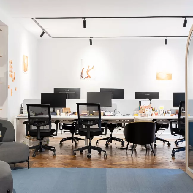 Espace de travail, quartier Archives, flexible avec des bureaux modulables, des chaises ergonomiques, et des séparateurs amovibles, permettant différentes configurations pour le travail collaboratif ou individuel.