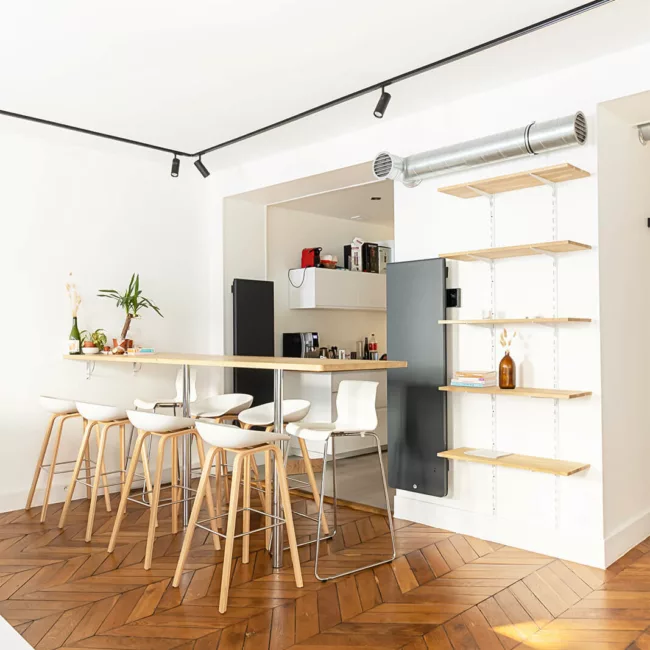 Espace de travail, quartier Archives, flexible avec des bureaux modulables, des chaises ergonomiques, et des séparateurs amovibles, permettant différentes configurations pour le travail collaboratif ou individuel.