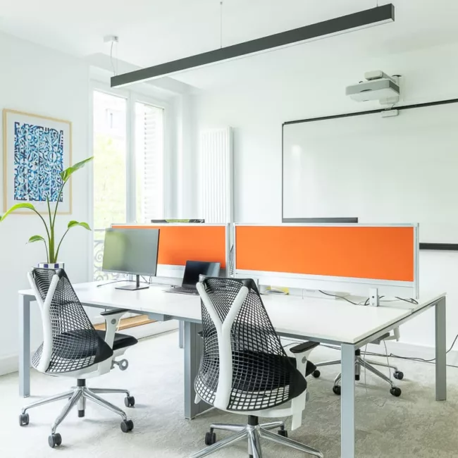 Espace de travail, quartier Réaumur-Sébastopol, flexible avec des bureaux modulables, des chaises ergonomiques, et des séparateurs amovibles, permettant différentes configurations pour le travail collaboratif ou individuel.