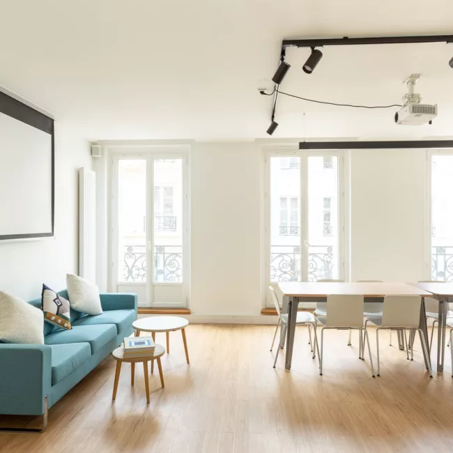 Espace de travail, quartier Réaumur-Sébastopol, flexible avec des bureaux modulables, des chaises ergonomiques, et des séparateurs amovibles, permettant différentes configurations pour le travail collaboratif ou individuel.