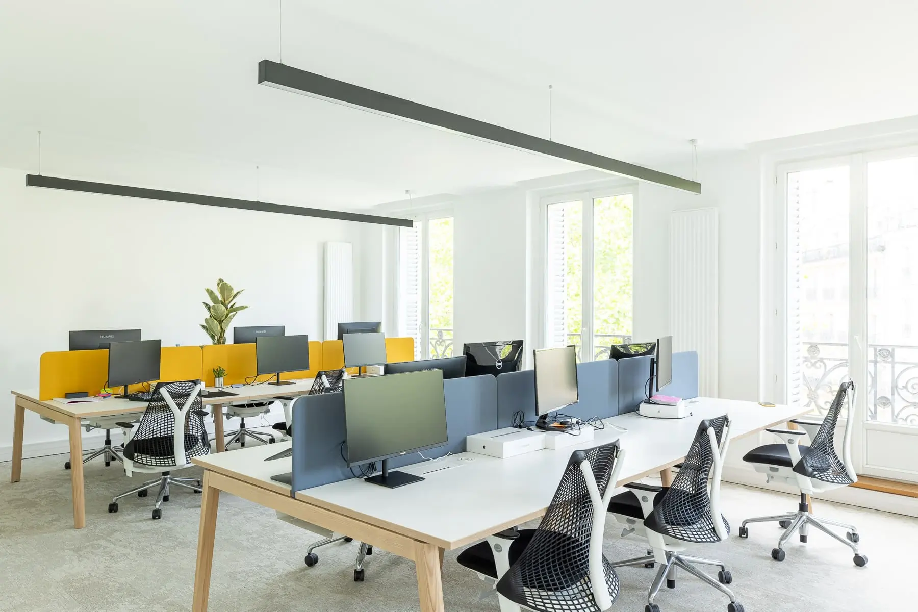 Espace de travail, quartier Réaumur-Sébastopol, flexible avec des bureaux modulables, des chaises ergonomiques, et des séparateurs amovibles, permettant différentes configurations pour le travail collaboratif ou individuel.