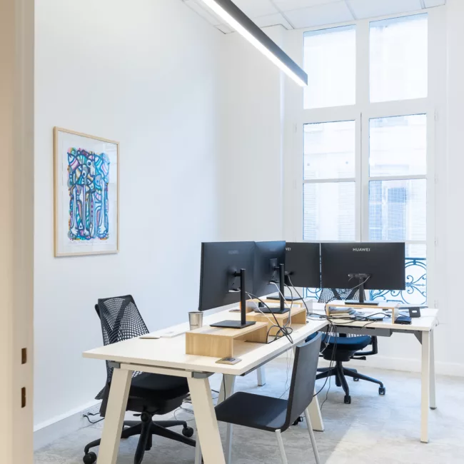 Espace de travail, quartier Pyramides, flexible avec des bureaux modulables, des chaises ergonomiques, et des séparateurs amovibles, permettant différentes configurations pour le travail collaboratif ou individuel.